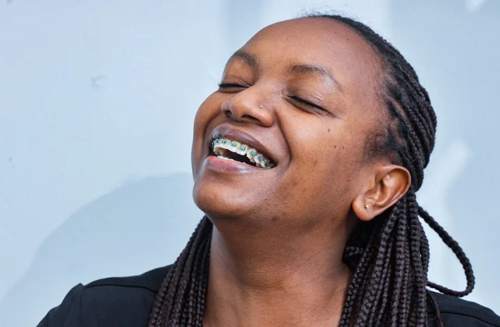 A client with braces smiling after Orthodontics treatment in Nakuru